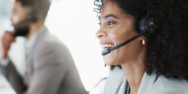 lachende Frau mit Headset am arbeiten