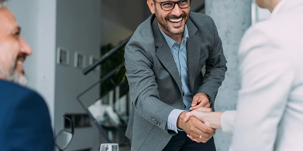 2 people shaking hands in smart clothes