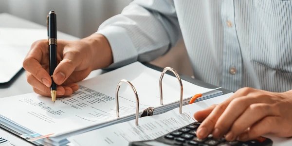Close-up of hands writing invoices