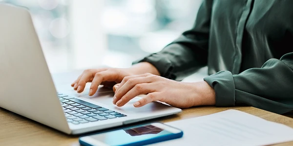 Close-up of hands working on laptop