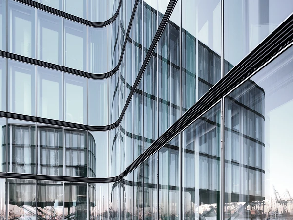 Modernes Gebäude aus Glas mit Spiegelung auf den Hafen